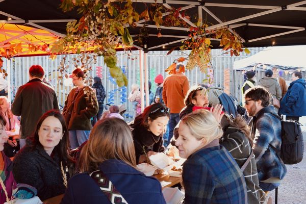 A long table with people eating outside - the community feast